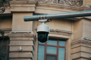Outdoor PTZ CCTV security camera mounted on a metal pole monitoring a residential building for 24/7 home surveillancOutdoor PTZ CCTV security camera mounted on a metal pole monitoring a residential building for 24/7 home surveillance and property security